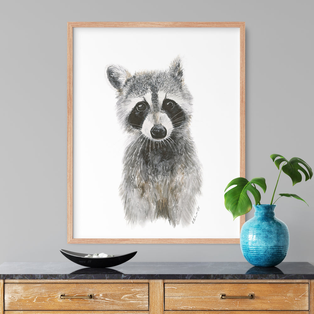 a picture of a raccoon in a frame on a table