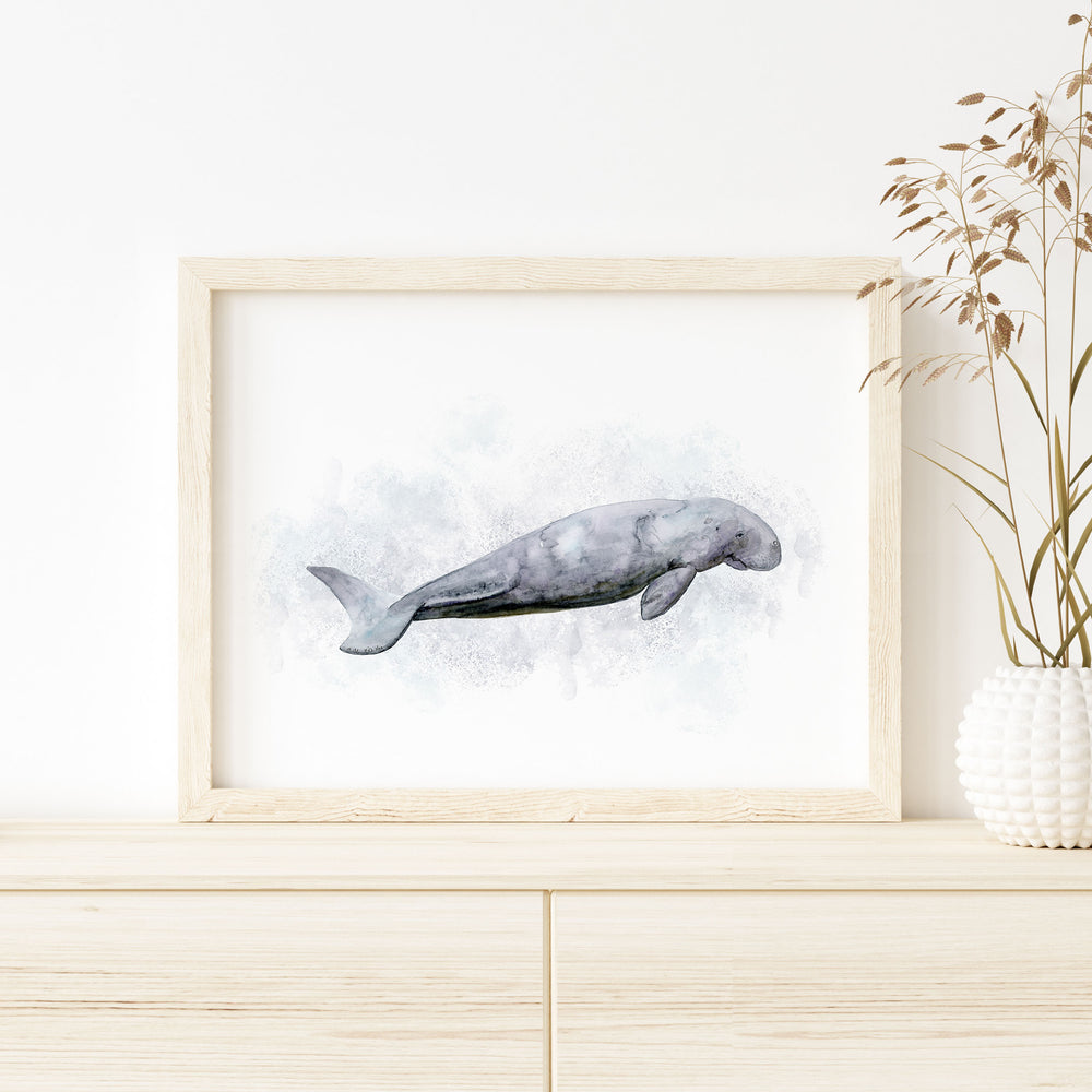 a picture of a dugong in a frame on a dresser