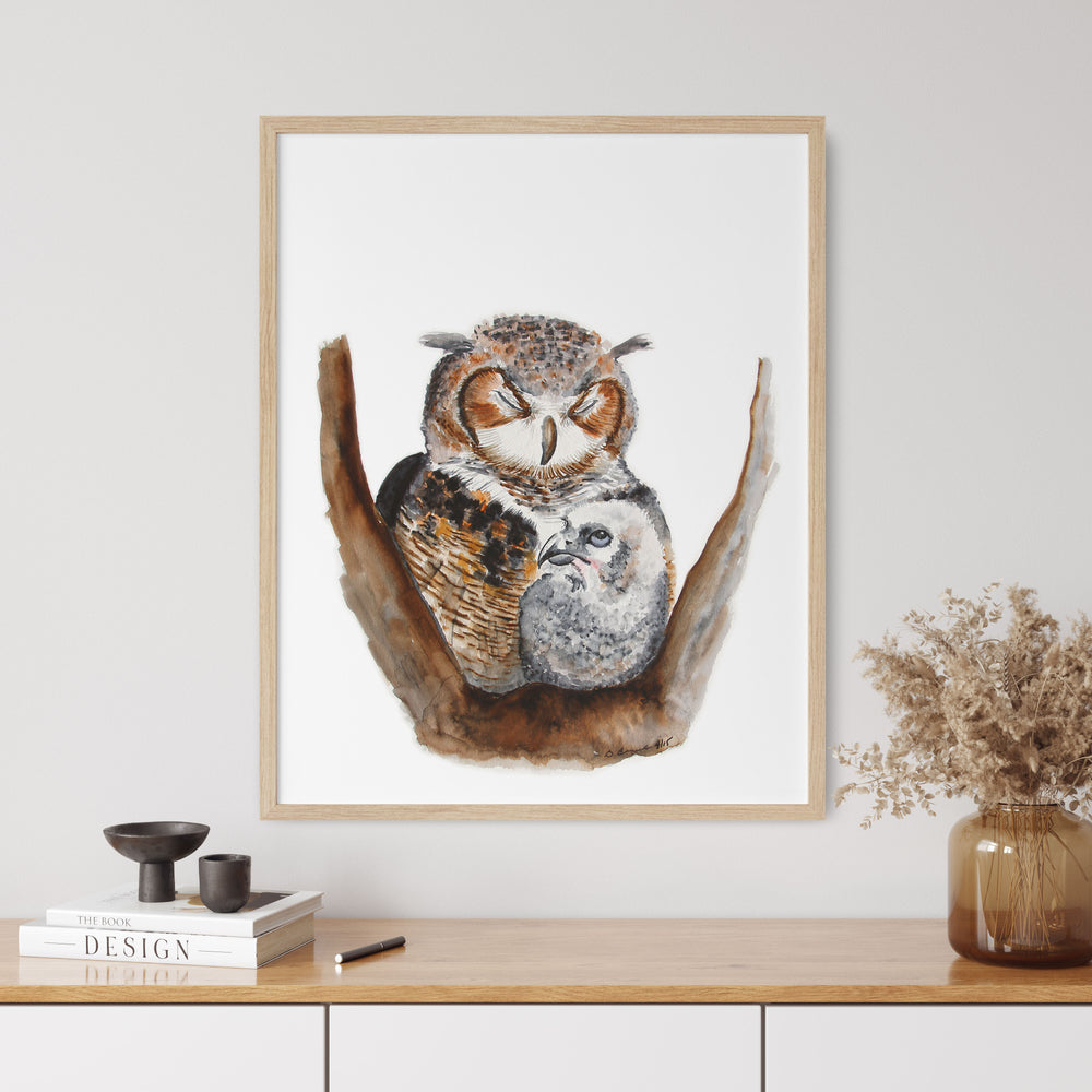 a picture of an owl and its baby sitting on a branch