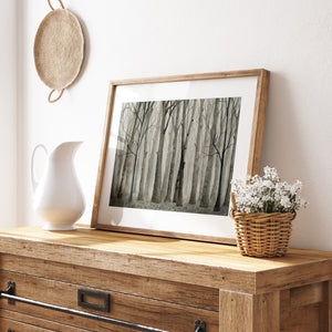 a picture of a tree in a frame on a dresser
