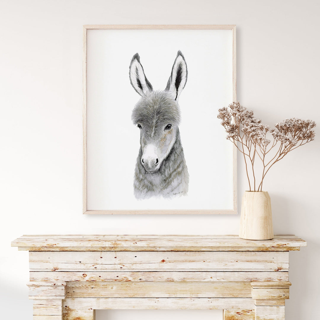 a picture of a donkey in a frame on a mantle