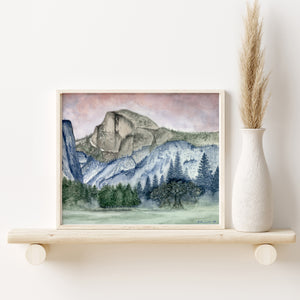 a painting of mountains and trees on a shelf