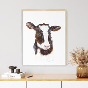 a picture of a cow is hanging on a wall