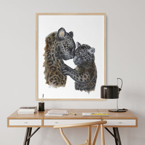 a picture of a mother and baby jaguar in a frame on a desk