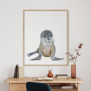 a watercolor print of a seal on a wall above a desk